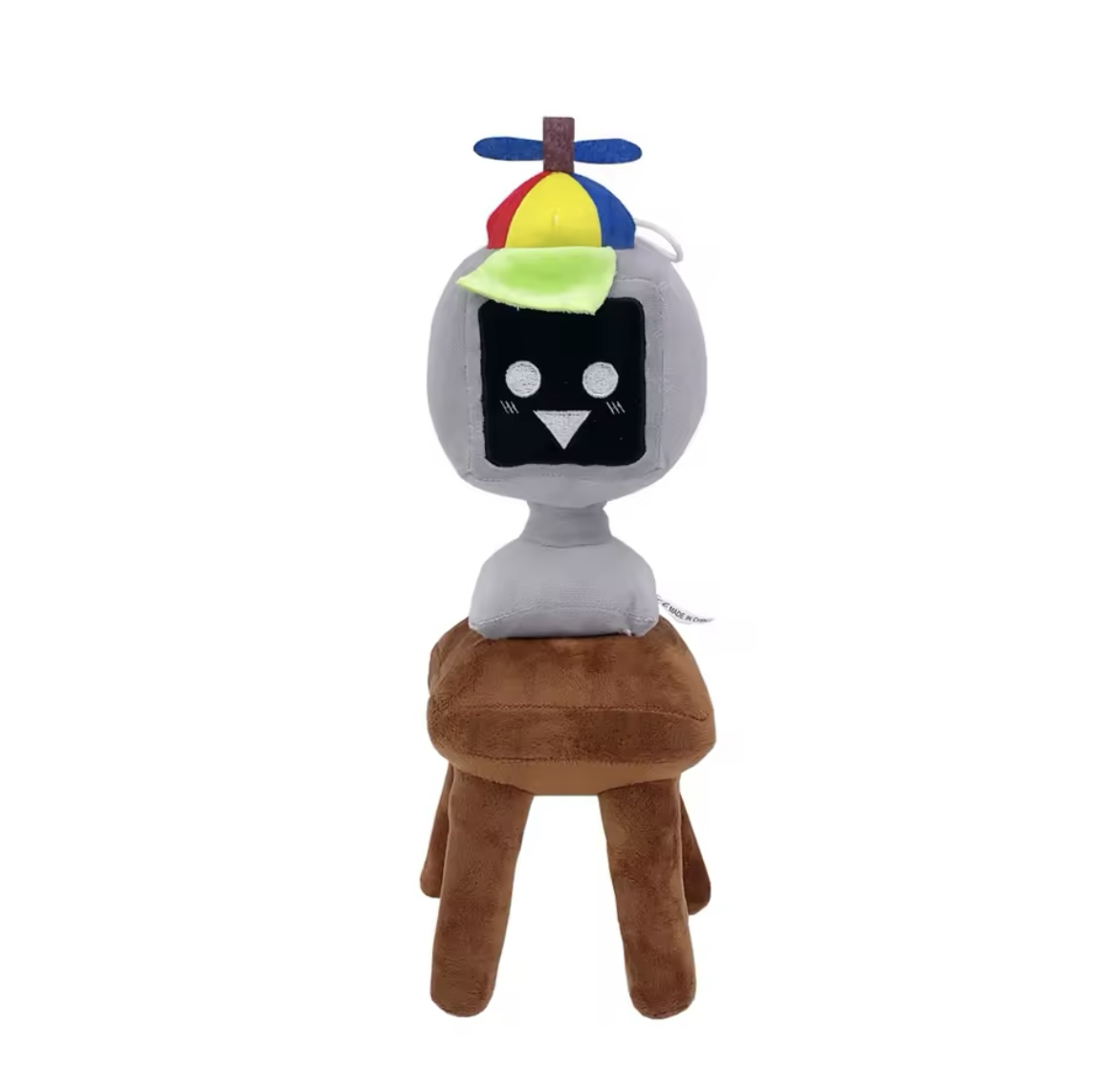 Mr Fun Computer Plush toy with a colorful hat and black face on a brown stool against a white background